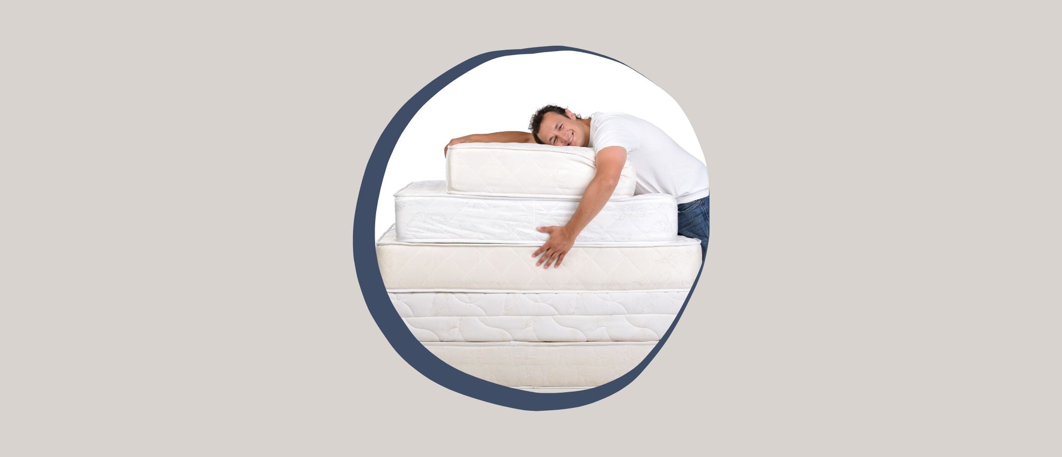 man hugging a heavy pile of mattresses