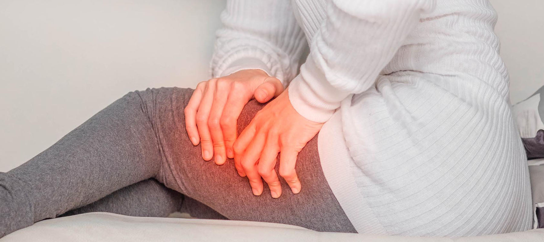 Woman holding her hurt thigh