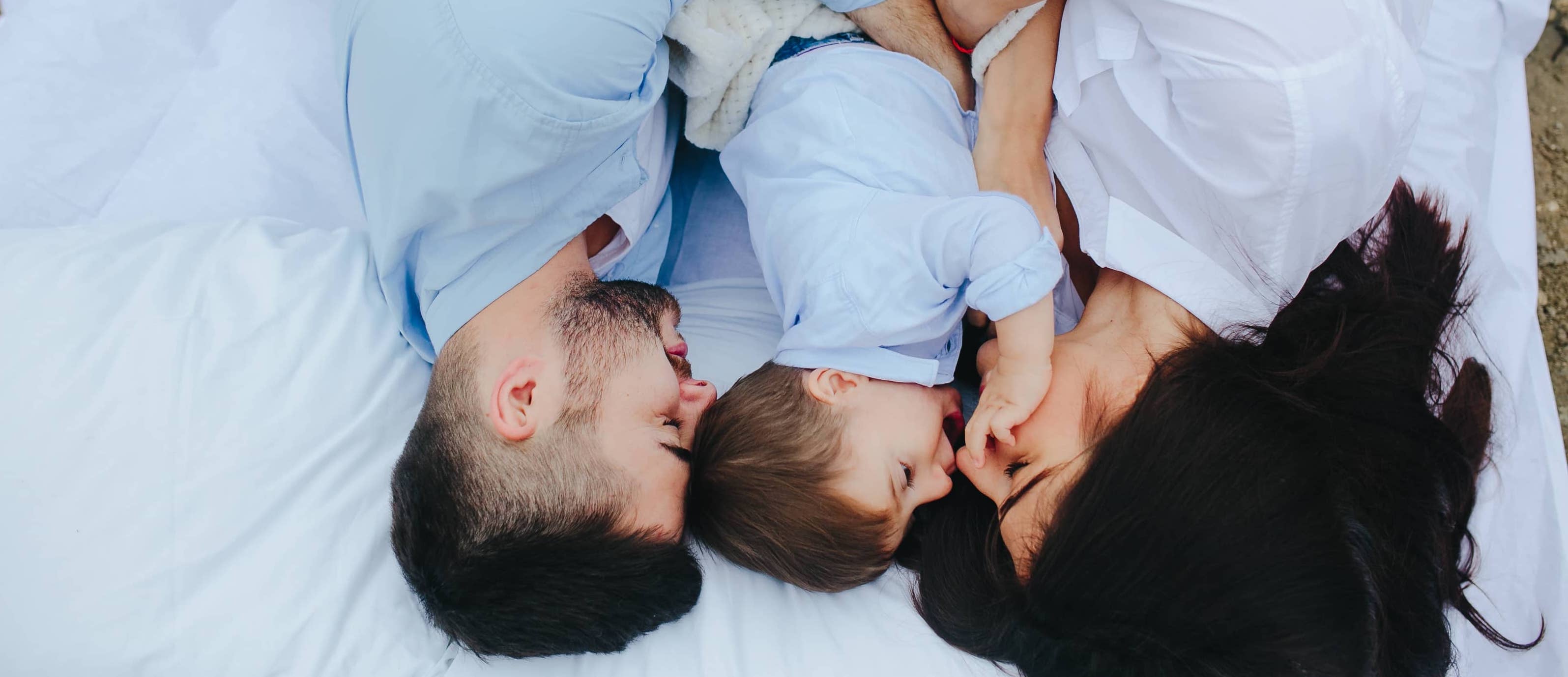 Little boy in bed between both his parents