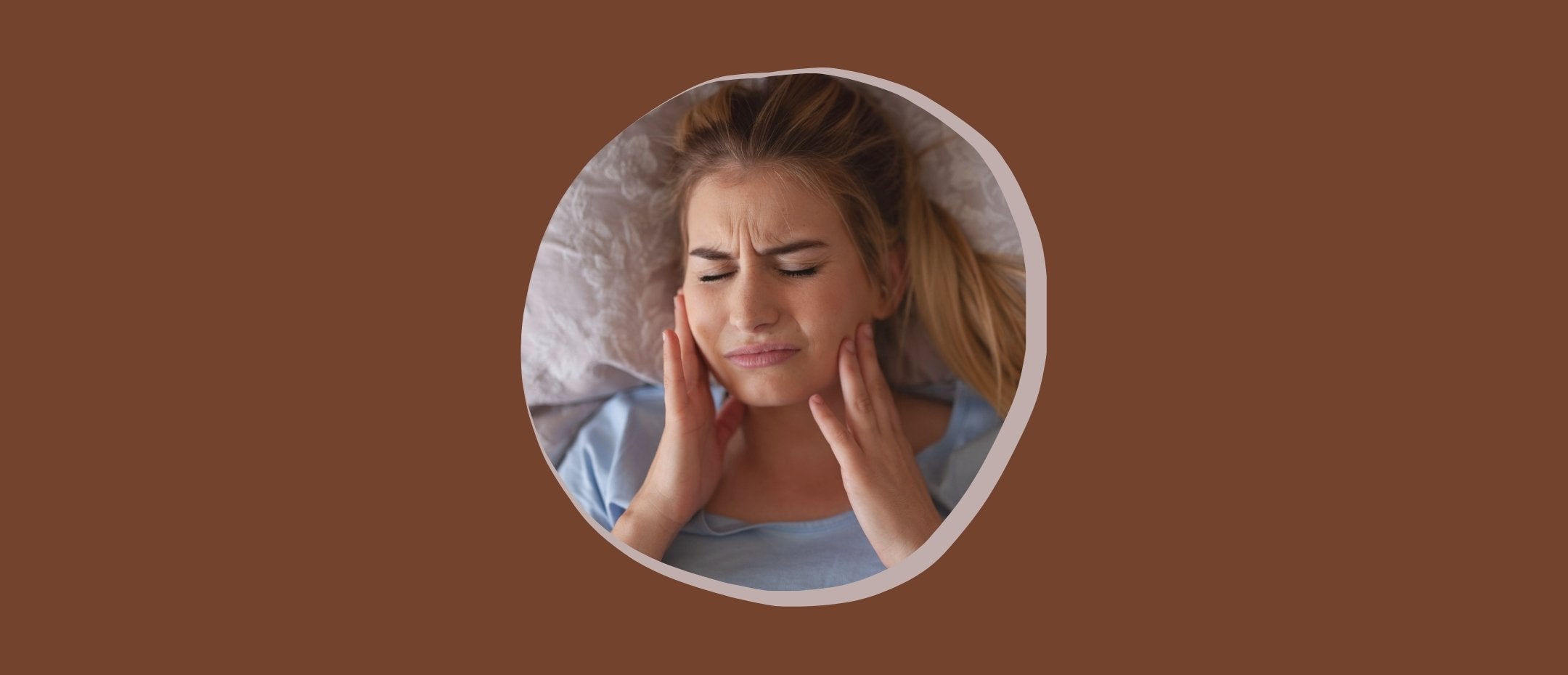 A woman wincing due to her toothache at night