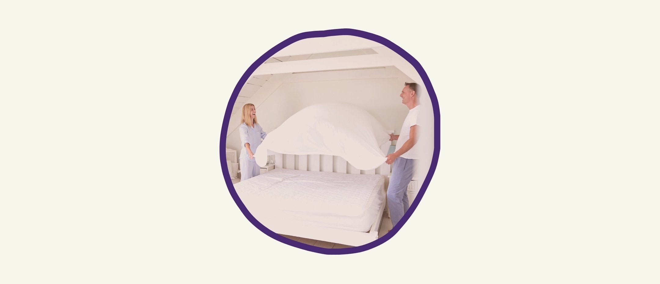 Couple making the bed with the sheet ready to be installed