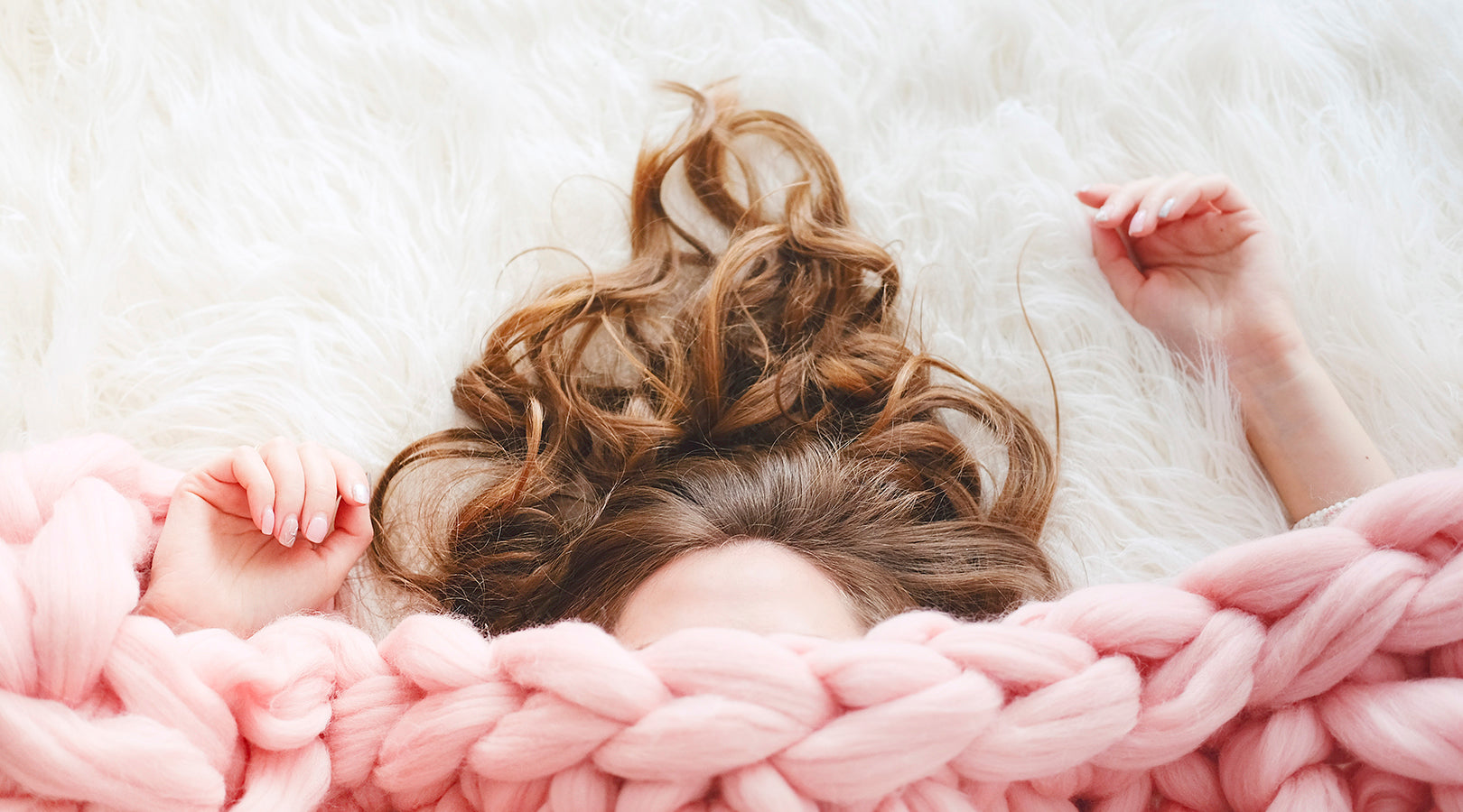 Woman napping under a blanket.