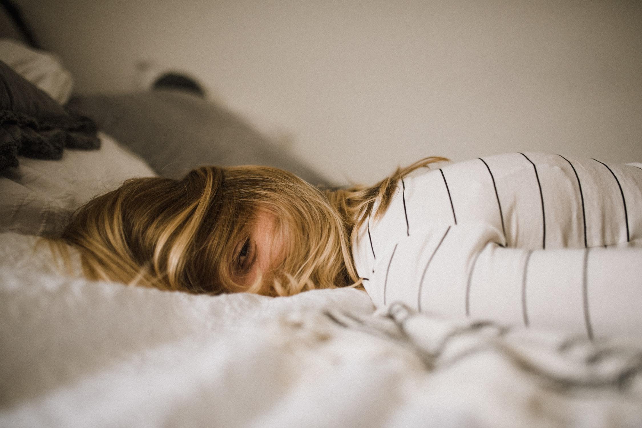 Exhausted woman lying on her bed.