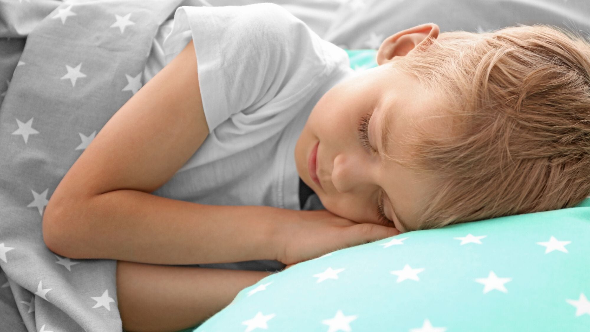 Little boy sleeping peacefully in bed.